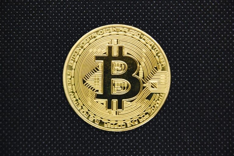 a gold coin with a bitcoin symbol on it