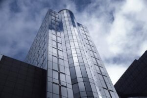 Modern glass building against cloudy sky