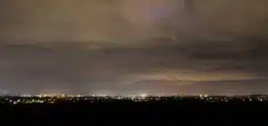 City lights under a cloudy sky.